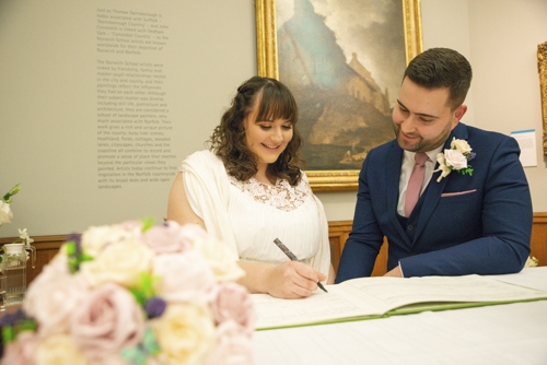 Photograph of Toby & Elizabeth Whittington signing the register during their wedding ceremony